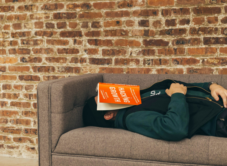 Άντρας κοιμάται σε καναπέ με βιβλίο στο πρόσωπο