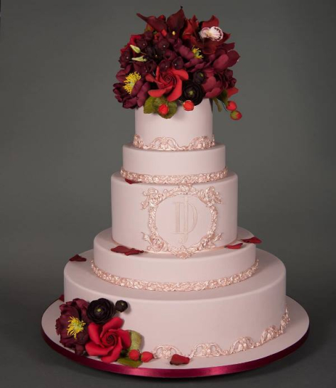 Ροζ τούρτα στολισμένη με κερασί λουλούδια.