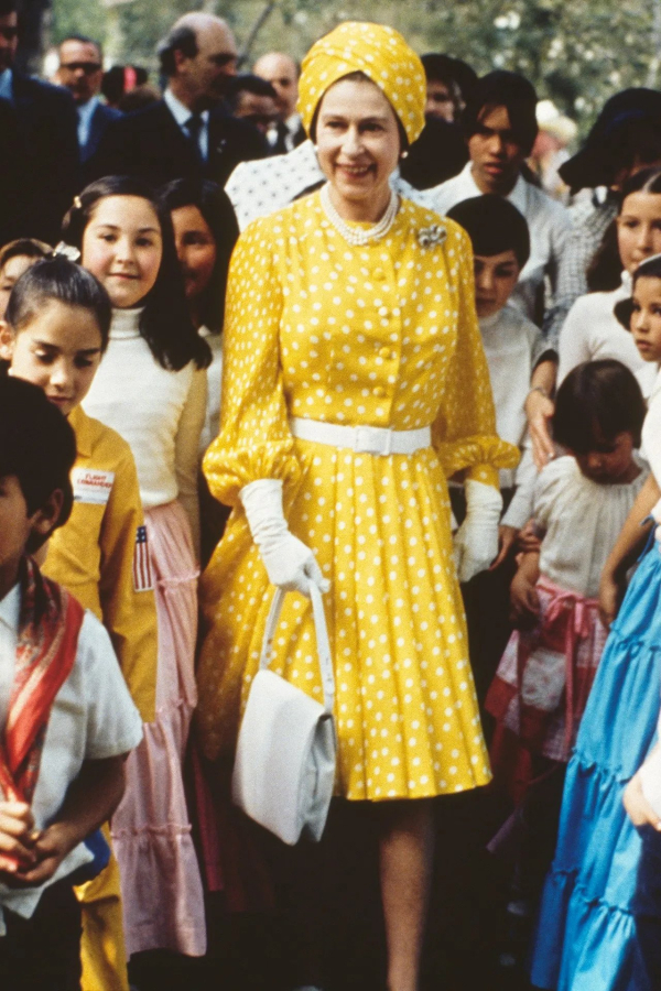 Φεβρουάριος 1975: Η βασίλισσα Ελισάβετ πέρασε χρόνο με μια ομάδα ντόπιων παιδιών κατά τη διάρκεια της επίσκεψής της στο Μεξικό φορώντας ένα κίτρινο πλισέ φόρεμα και τουρμπάνι.
