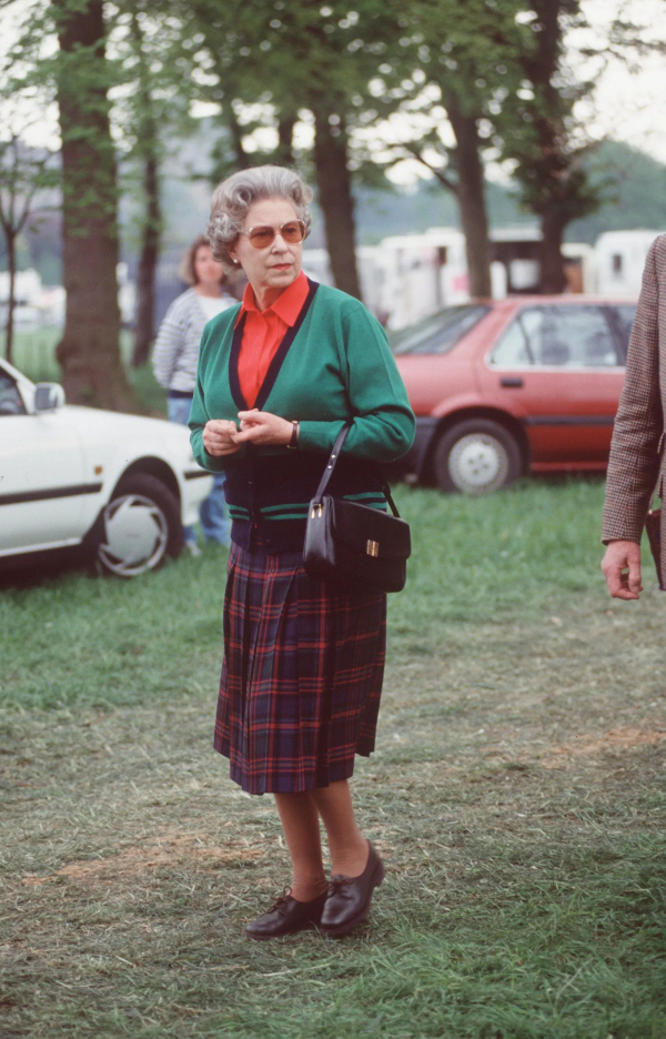 10 Μαΐου 1991: Η βασίλισσα συνδύασε μια πράσινη ζακέτα με κόκκινο πουκάμισο και φούστα ταρτάν για το Royal Windsor Horse Show.
