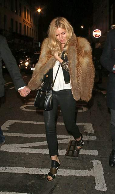 Sienna Miller is seen here leaving The Groucho Club in Soho  London at 2am Holding hands with a Unknown Male companion  rSienna looked very fashionable wearing a faux fur jacket along with a pair of black PVC trousers   black   gold high heels whilst carr