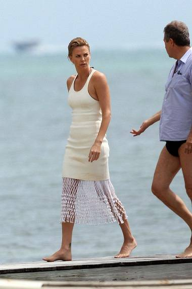 115053 Charlize Theron gets a visit from son Jackson while on a photo shoot in Miami Beach At one point an unidentified older gentleman had his arm around her waist as they walked on a dock Theron made a number of outfit changes to include a creme co