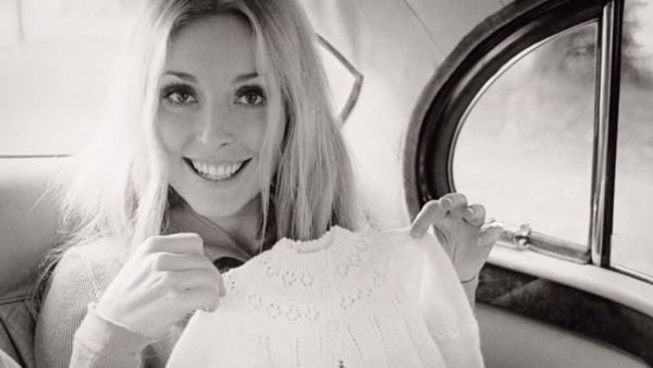 Κρατώντας βρεφικό ρούχο, περιμένοντας το πρώτο της παιδί