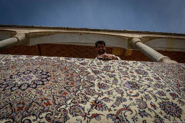 Ένας άνθρωπος πλένει ένα χαλί στο Isfahan Bacarkard Bazar