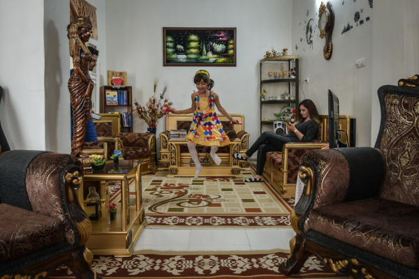 Ένα κορίτσι παίζει με ένα σχοινί στο σπίτι, ενώ η μαμά της διαβάζει