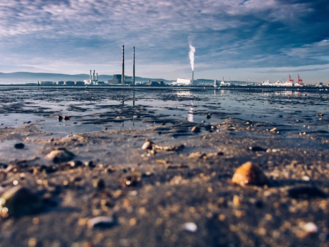 Μολυσμένη λίμνη με εργοστάσιο στο βάθος