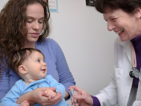 Μωρό στην αγκαλιά της μαμάς του κάνει εμβόλιο