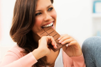 happy-woman-taking-bite-of-chocolate-barκαθετα.jpg